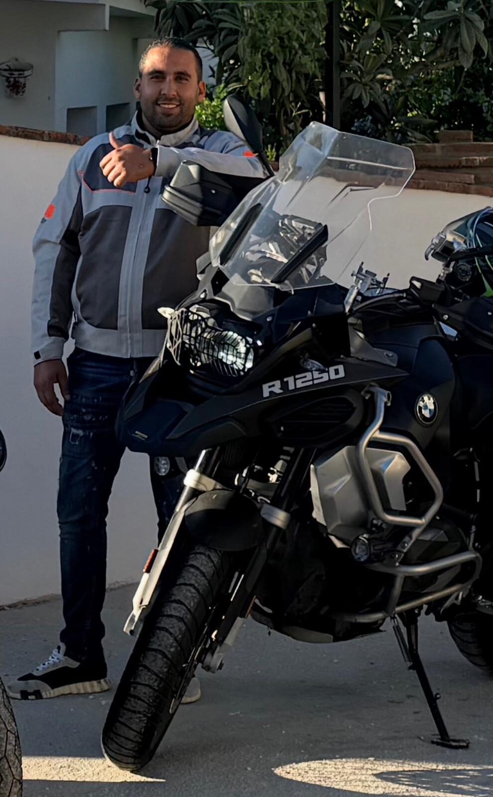 Motorrijder in motorkleding naast een BMW R 1250 van Mayar Rijopleidingen